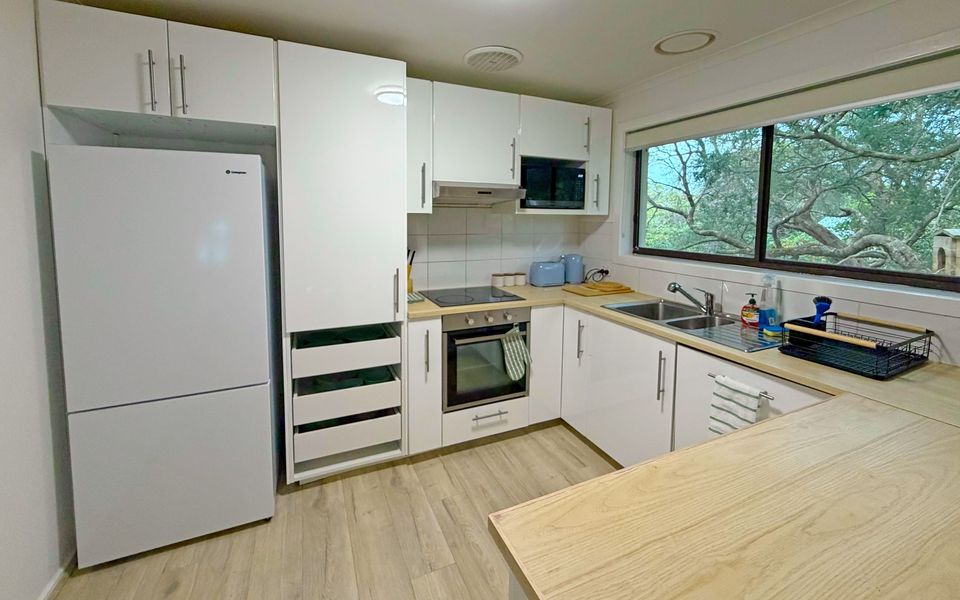 Fully equipped kitchen with everything you need, including a microwave, coffee machine, oven, electric cooktop, and dishwasher.