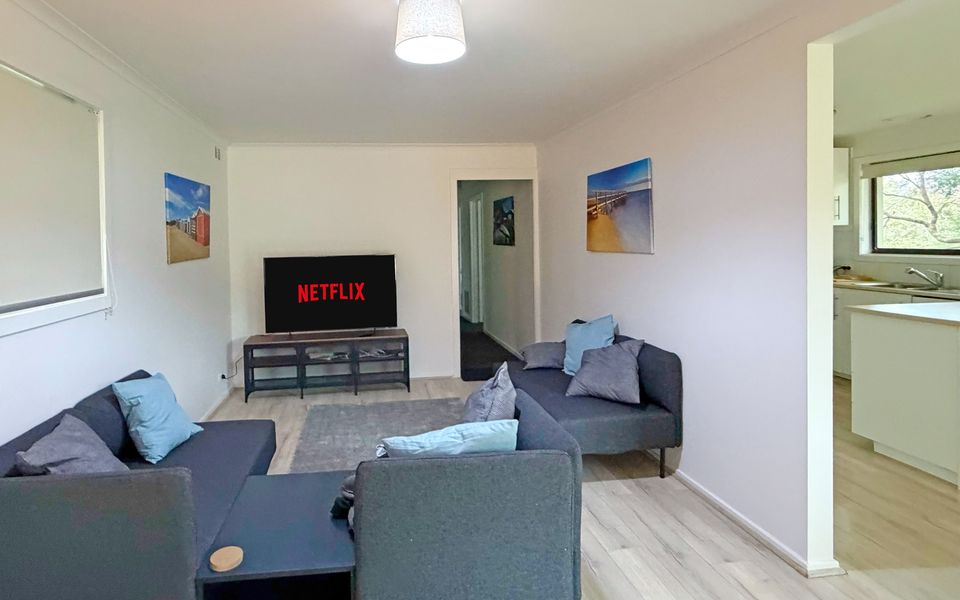 Open-plan living area with a Smart TV and comfortable couches, perfect for relaxing after a day at the beach.