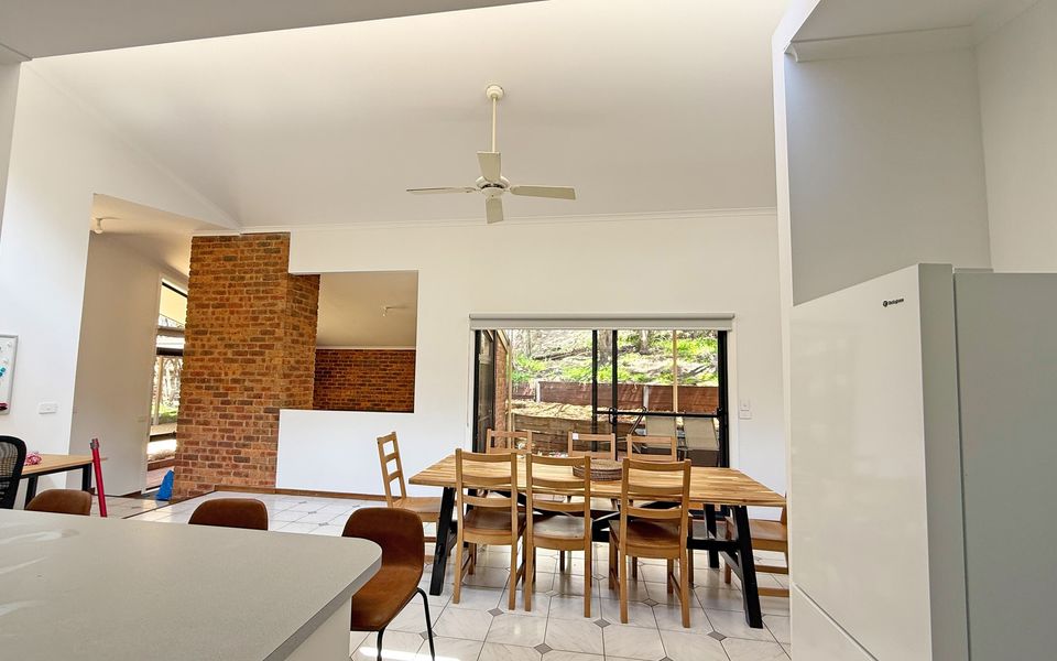 Spacious dining and kitchen space with split-system comfort and a breakfast bench with stools.