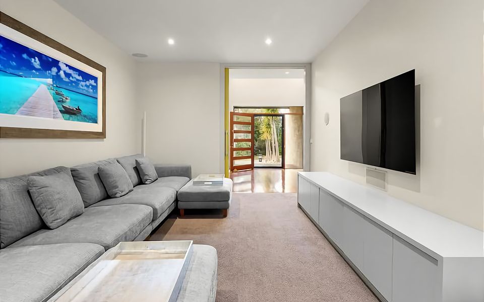 TV room with sound system and huge, plush sofa.