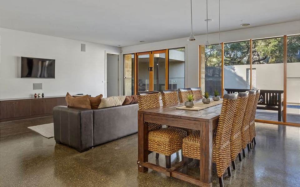 Immerse yourself in the inviting atmosphere of our Airbnb space, featuring a spacious dining table and lounge area that offer both functionality and comfort.