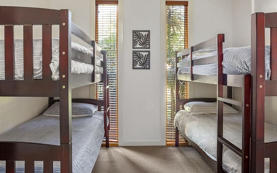 Relax and unwind in our modern room featuring two sets of single bed bunks, ensuring a comfortable and restful sleep for everyone.