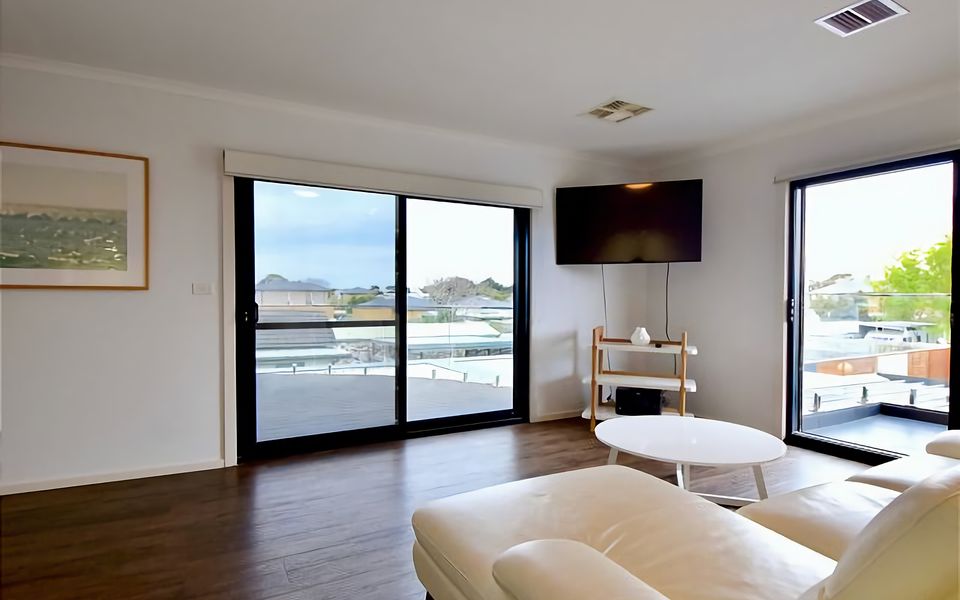 Upstairs lounge room with access to two balconies and TV.