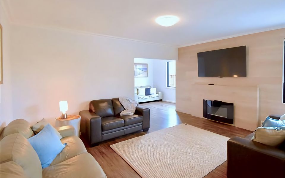 Downstairs Lounge with gas-fired fireplace and large flatscreen TV.
