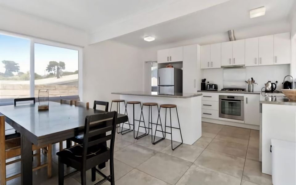 Spacious kitchen/dining equipped with generous island bench with four breakfast stools.