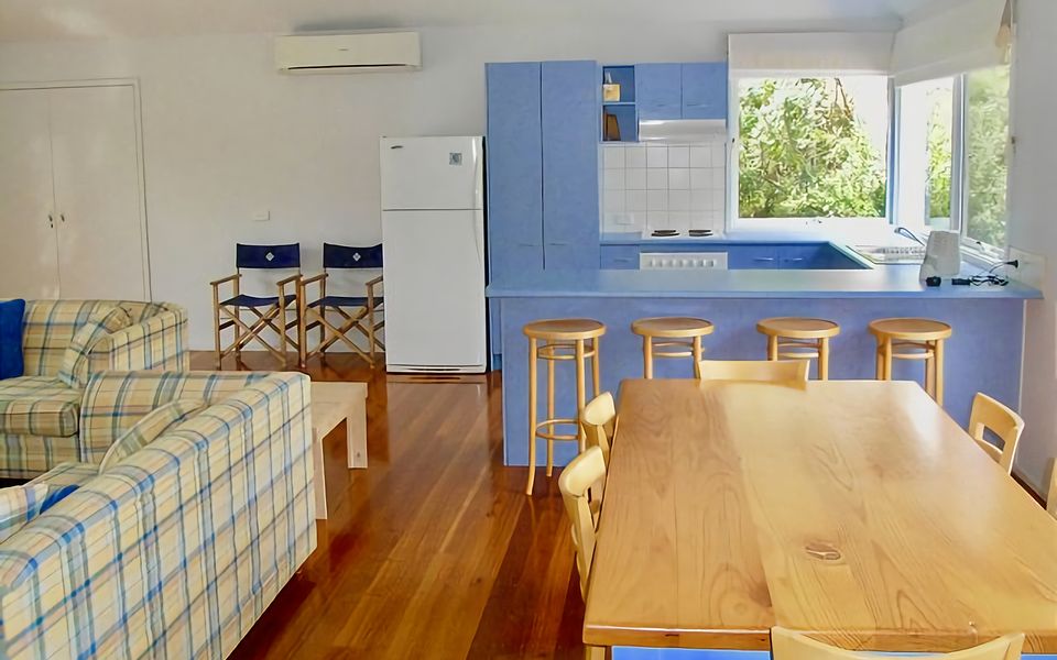 Natural light filled kitchen with breakfast bar and dining area.