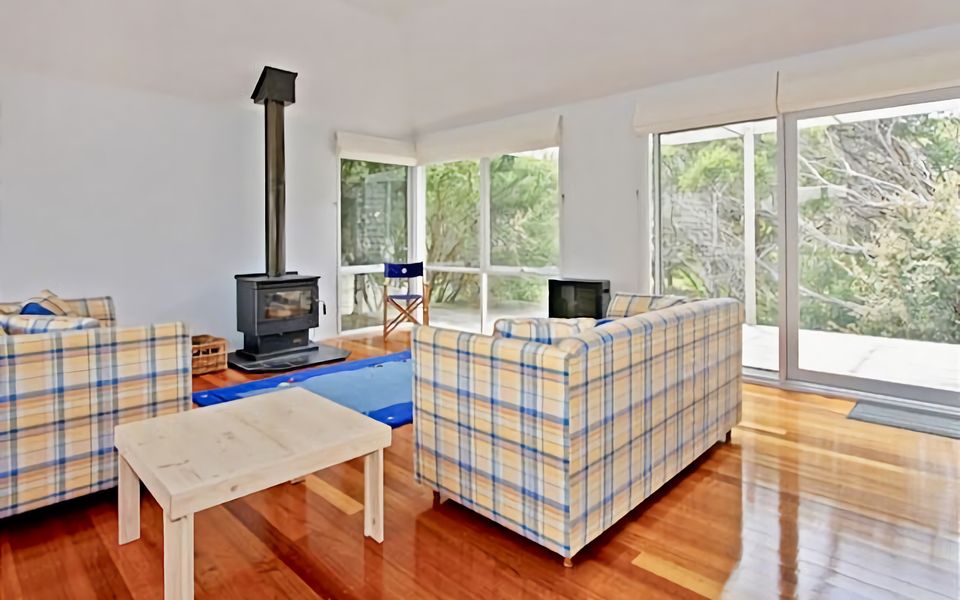 Lounge room has two cosy couches with wood fireplace.
