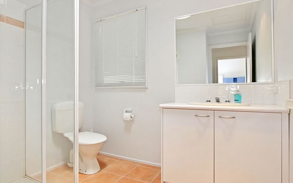 Main bathroom has shower, vanity, and toilet.