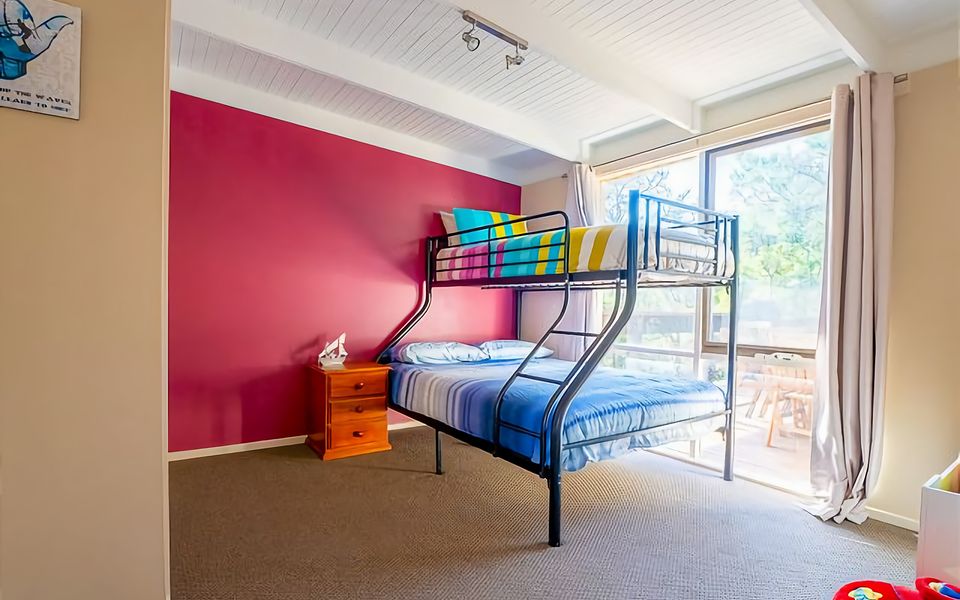 Second bedroom with a Tri Bunk - double with single over and delightful views of the native seaside greenery.