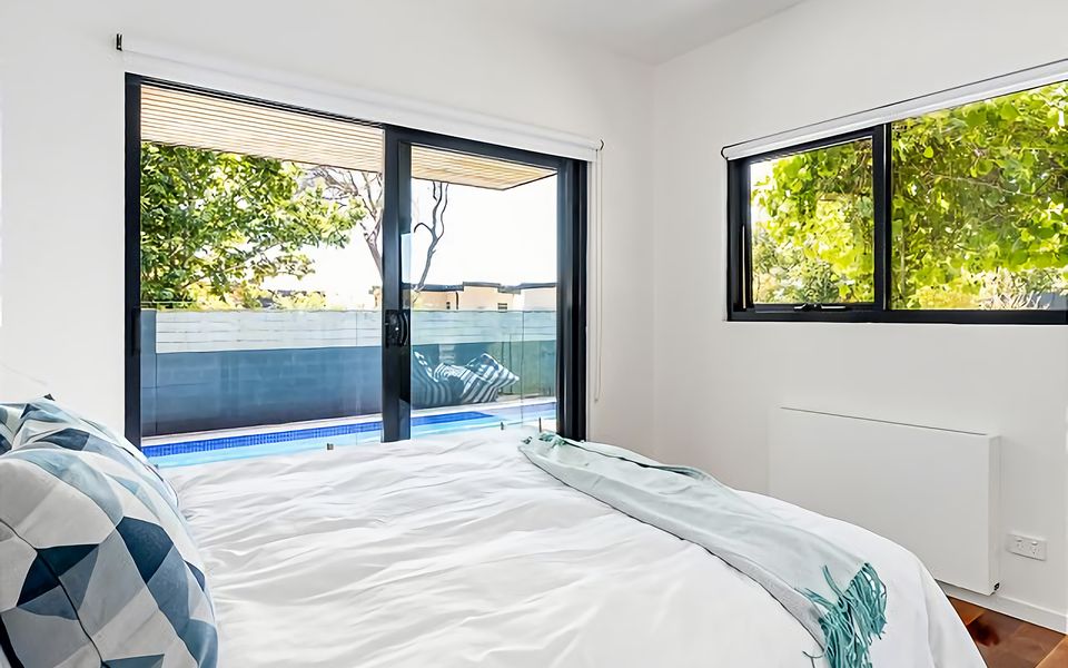 Bedroom with King bed, sliding door access to the deck and peaceful views onto the backyard.