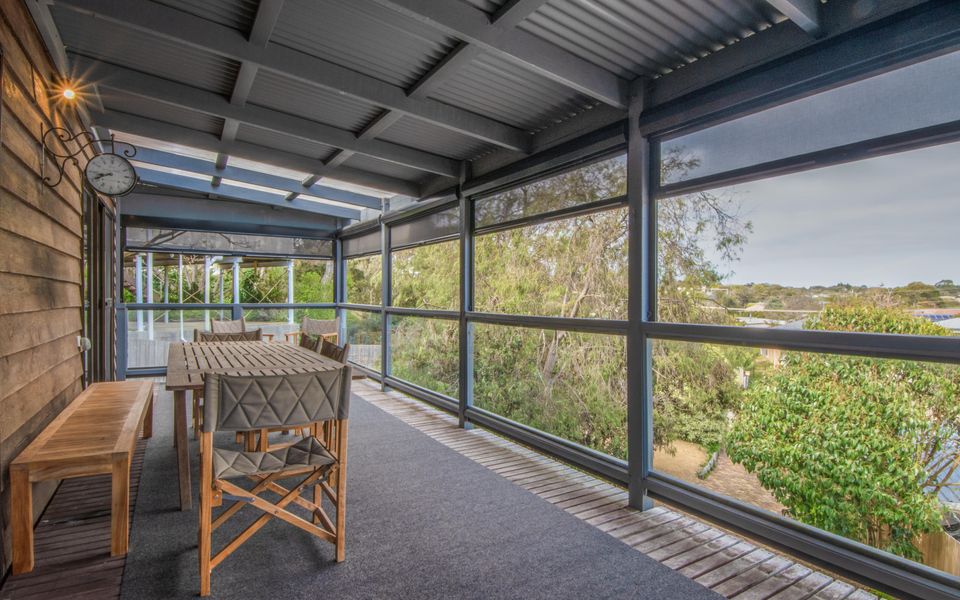 The balcony with dining for 10 people, 2 lounge chairs, Weber BBQ and bar fridge.