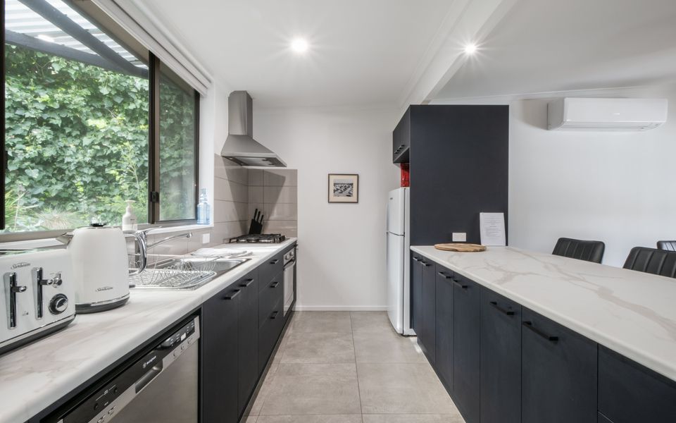 Kitchen with large kitchen bench and four stools