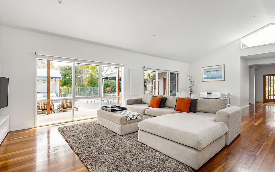 Main space off the kitchen offers comfortable couch with pool views TV and DVD player.