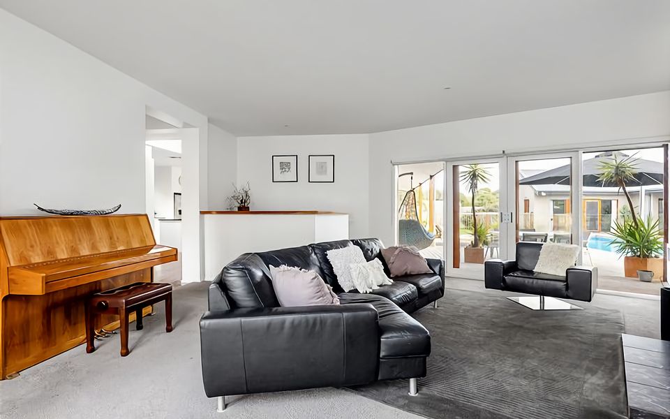 Lounge space with couches, bar, piano, wood fireplace, rear deck access.