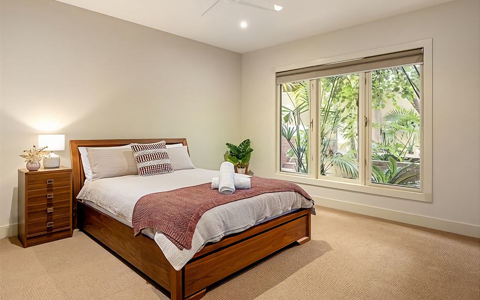 3rd Bedroom with Queen bed, air conditioning, WIR, ceiling fan, and view of the garden.