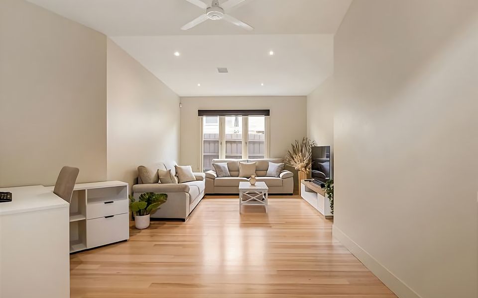 First lounge with a great work area with a desk, a sitting area with 2 double couches, TV, soundbar, and ceiling fan.