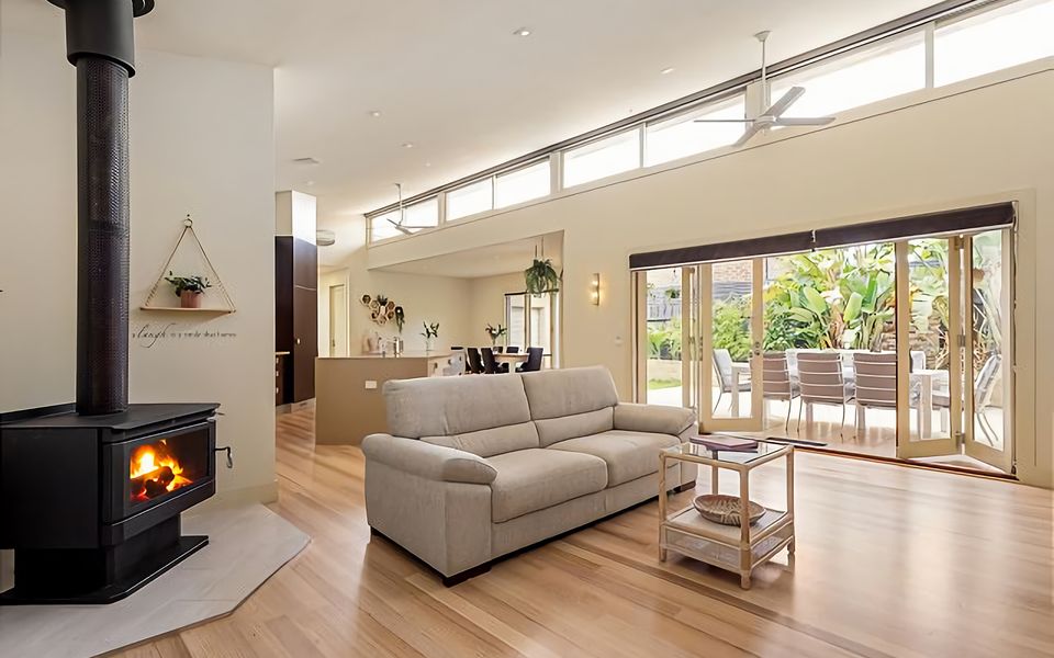 Lounge area with wood- burning fireplace, large Smart TV and bi-fold door access to the alfresco dining area.