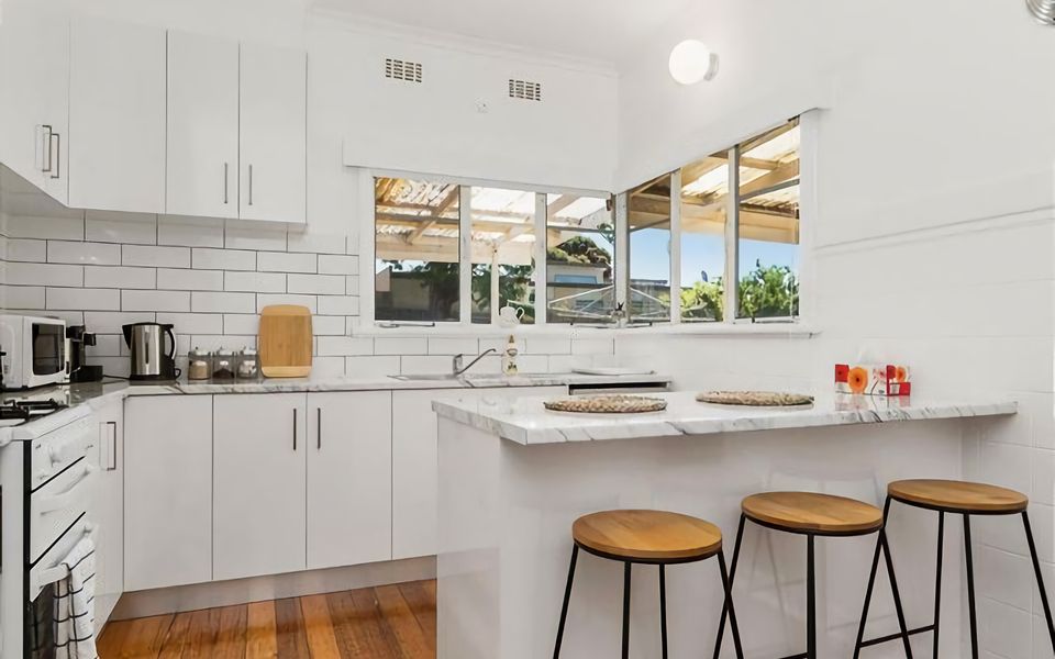 The bright and modern family kitchen, perfect for preparing holiday dinners or big breakies featuring a central breakfast bar,