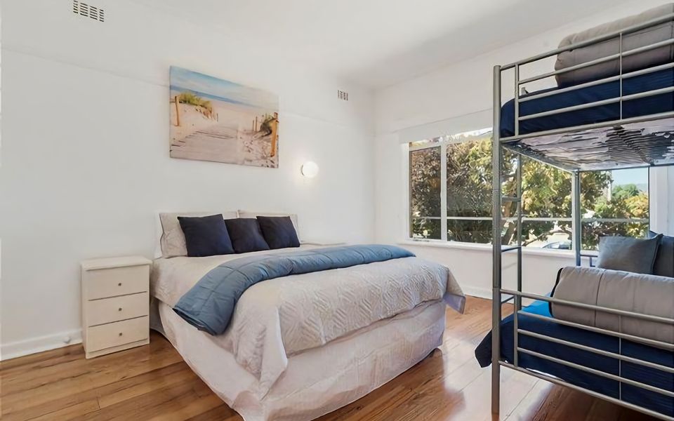 Sleep in comfort and luxury with our spacious bedroom featuring a stylish queen bed and set of single bunks.