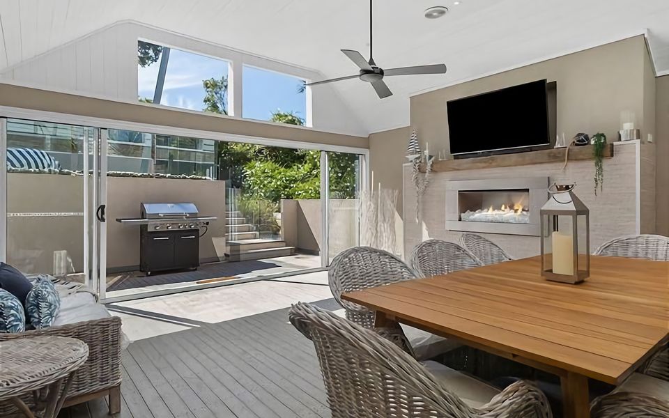 Discover a delightful covered outdoor area, thoughtfully designed with a comfortable table for outdoor meals. On chilly evenings, gather around the mesmerizing gas log fire while the sliding doors allow you to bring the outside in.