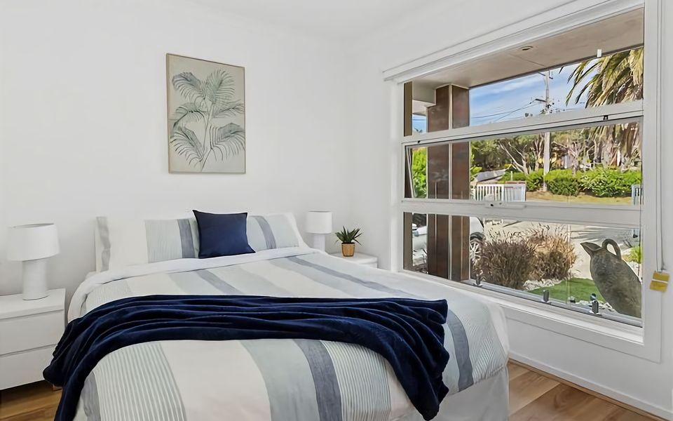 Embrace the comforts of home in our inviting bedroom, furnished with a queen bed and adorned with cozy blankets, creating a cozy ambiance for a peaceful stay.