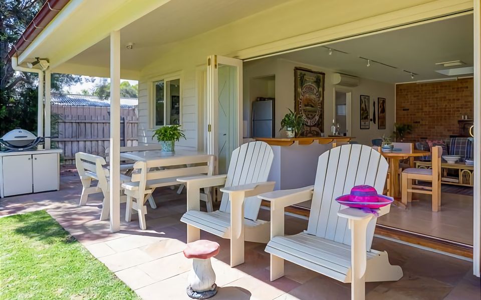 Covered area with table and seating, garden area and Gas BBQ.