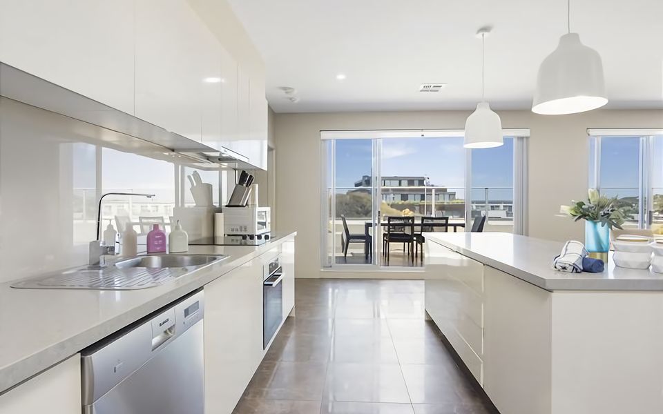 A contemporary kitchen leek stainless steel appliances and a chic breakfast bar.