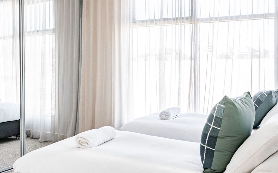 Second bedroom with two single beds and wardrobes.