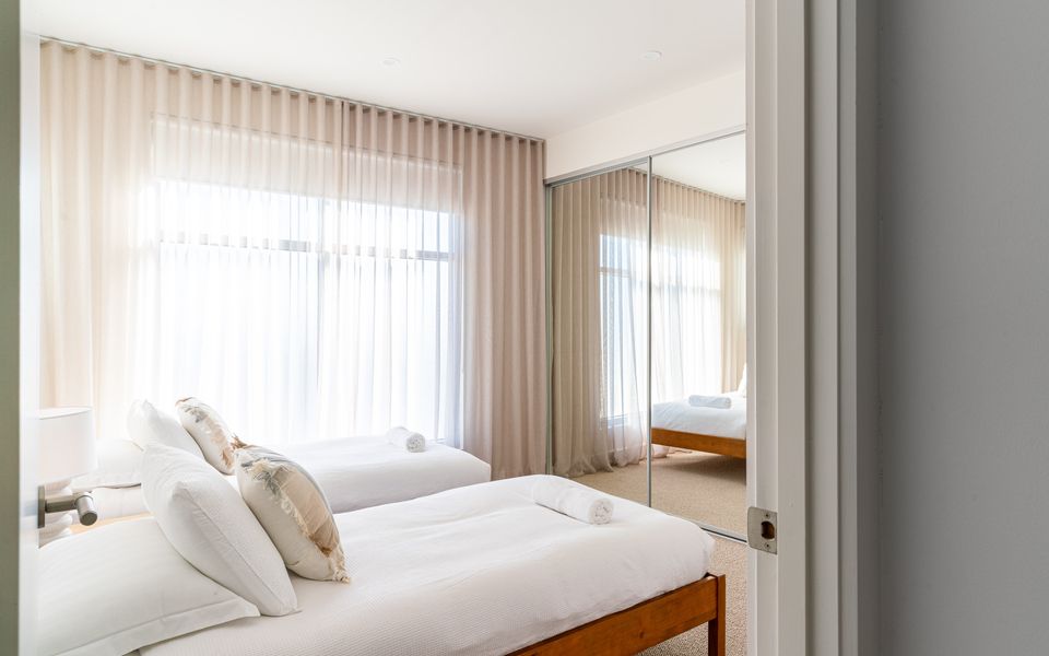 Second bedroom with two single beds, wardrobes and a TV, all linen is provided.