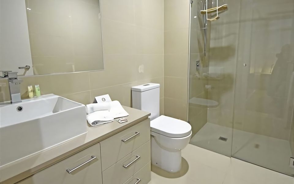 Main bathroom with shower, vanity and toilet.