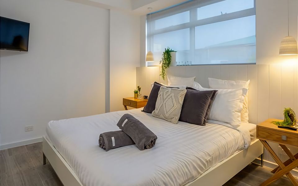 Enjoy a peaceful night's sleep in this elegantly furnished bedroom, complete with a comfortable king bed and a contemporary ensuite bathroom. The perfect combination of style and comfort.