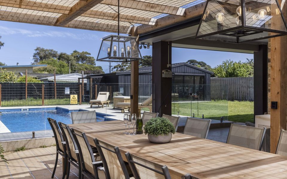 Outdoor dining overlooking pool and fully fenced garden area