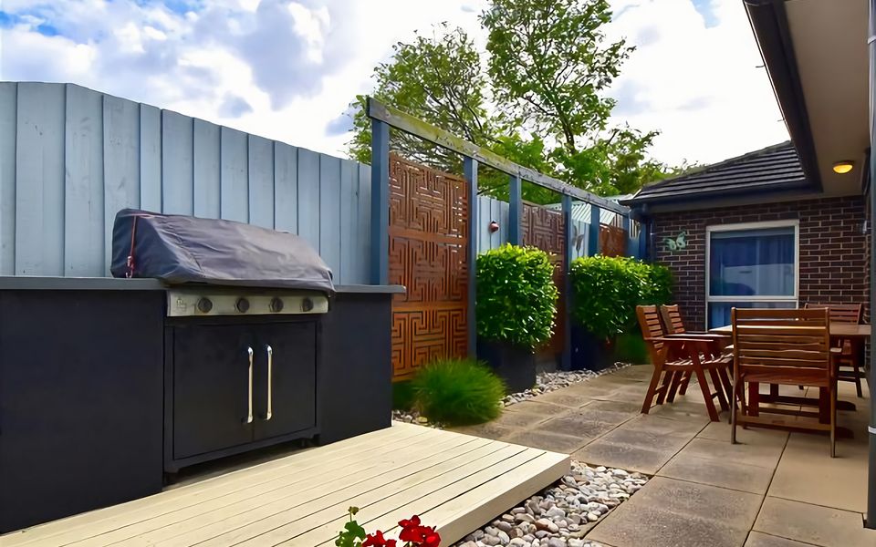 Paved and fully enclosed rear patio with seating for 4-6 people and gas BBQ.