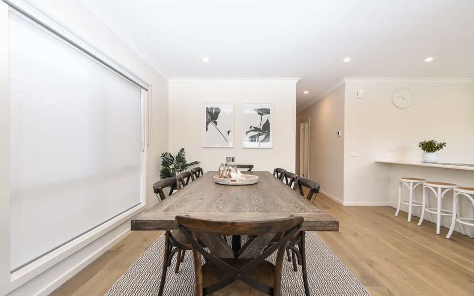 Elegance meets functionality in our spacious dining area, featuring a sizable wooden dining table.