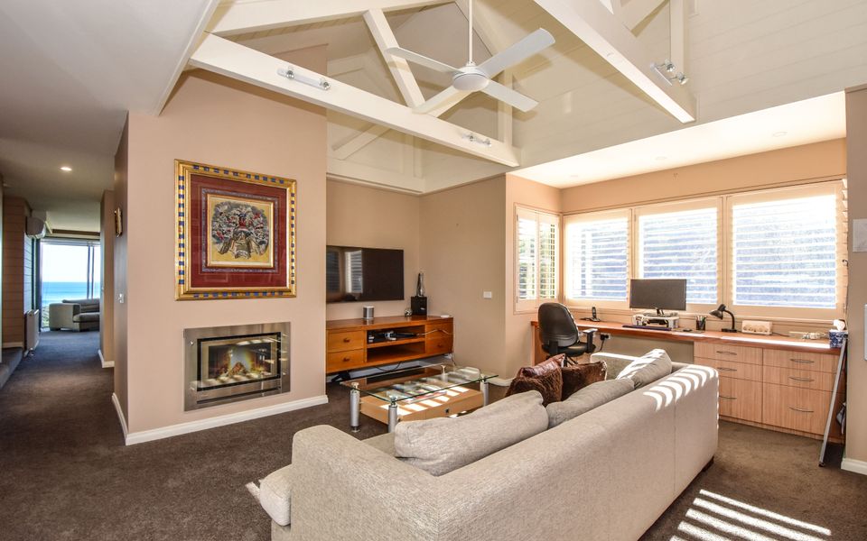 Spacious study complete with large desk, TV, fireplace lounge suite, and poolside access.