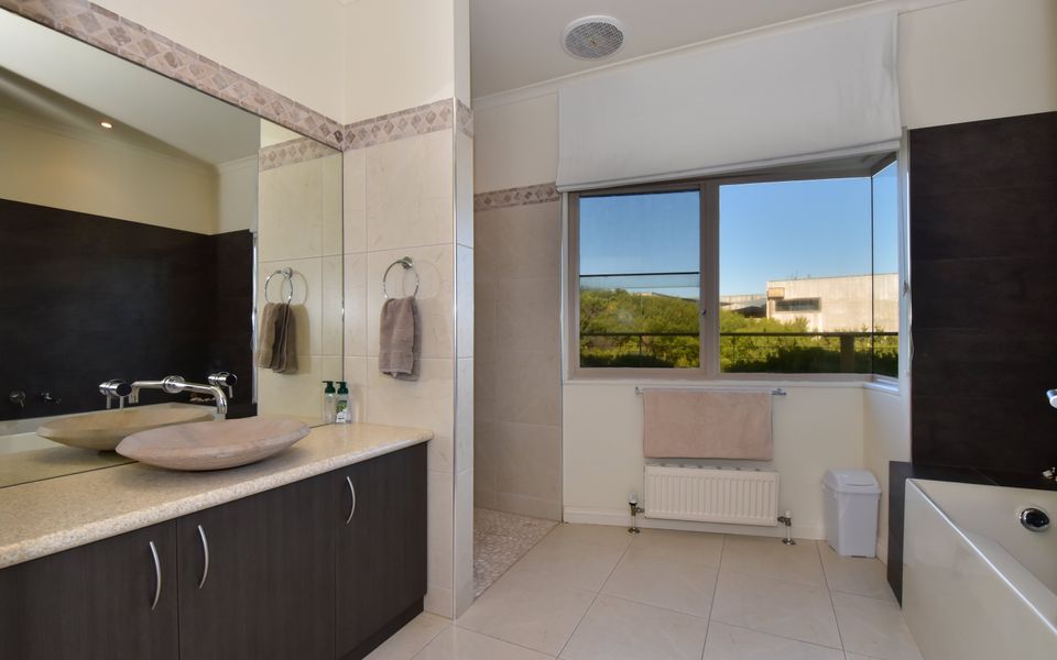 Main bathroom with shower, bath and basin.