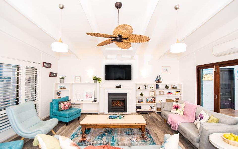 Lounge room featuring comfortable couches surrounding a cozy wood-burning fireplace.