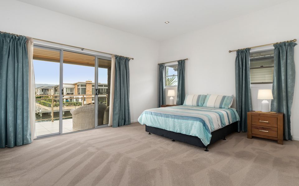 Master bedroom with ensuite, desk, couch, TV, private balcony and Queen bed