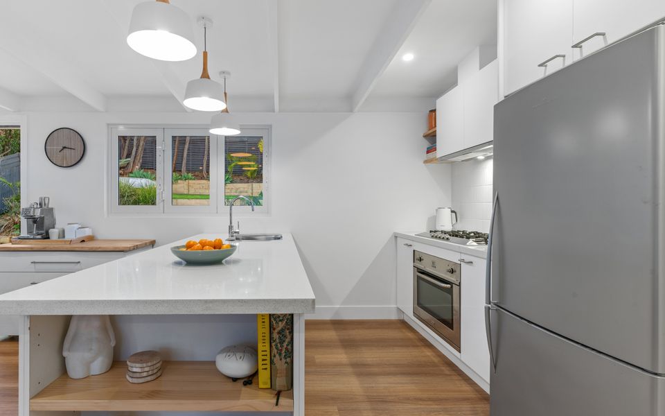 Fully equipped kitchen with bi-fold windows that open up to the alfresco bar with stools. Perfect for entertaining.