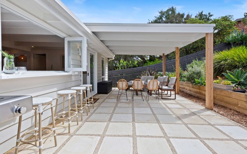 Lovely outdoor entertaining area under the pergola, complete with alfresco bar with stools.